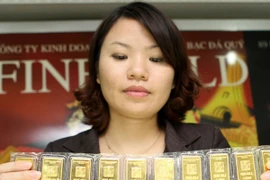 Nhân viên đang kiểm tra chất lượng vàng miếng trước khi giao dịch (Ảnh: TTXVN)