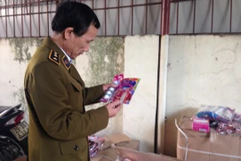 Cán bộ Đội Quản lý thị trường số 6 Hà Nội kiểm tra lô bánh kẹo nhập lậu đội lốt hàng Việt Nam (Ảnh: Đức Duy/Vietnam+)