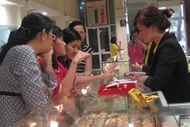 Khách hàng đang giao dịch vàng miếng (Ảnh: TTXVN)