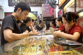 Khách hàng đang giao dịch vàng miếng tại hệ thống Bảo Tín Minh Châu (Ảnh: TTXVN)
