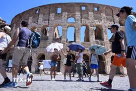 Khách du lịch tham quan tại điểm du lịch nổi tiếng Đấu trường La Mã Colosseum của Italy. (Ảnh: TTXVN)