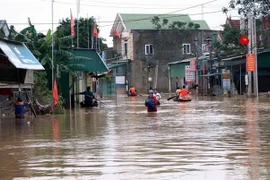 Lực lượng cứu trợ và các nhà hảo tâm vận chuyển hàng tới cho nhân dân vùng lũ. (Ảnh: Công Tường/TTXVN)