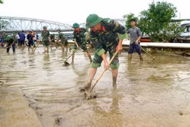  Cán bộ, chiến sỹ cùng người dân khẩn trương dọn vệ sinh. (Ảnh: Tường Vi/TTXVN)