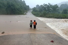 Mưa lớn khiến một số đường giao thông gây khó khăn và nguy hiểm cho người dân. (Ảnh: TTXVN phát)