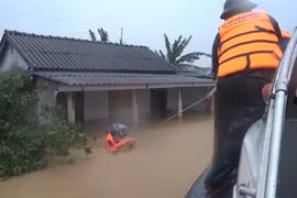Bộ đội Biên phòng tỉnh Quảng Trị di dời những người dân bị mắc kẹt trong lũ đến nơi an toàn. (Ảnh: Hồ Cầu/TTXVN)