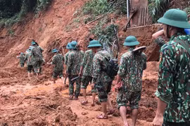 Lực lượng cứu hộ, cứu nạn hành quân tới hiện trường vụ sạt lở trong điều kiện vô cùng khó khăn do đường giao thông có nhiều điểm bị sạt lở nghiêm trọng. (Ảnh: Thanh Thủy/TTXVN)