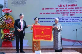 Ông Vương Đức Hoàng Quân, Chủ tịch Liên hiệp các tổ chức hữu nghị Thành phố Hồ Chí Min,h trao Cờ truyền thống của UBND Thành phố tặng Hội hữu nghị Việt Nam-Cuba Thành phố. (Ảnh: Xuân Khu/TTXVN)