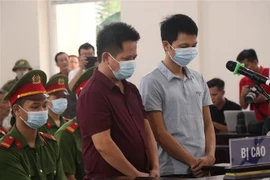 Bị cáo Nguyễn Văn Thiện và Lăng Văn Vân tại phiên tòa. (Ảnh: Thanh Thương/TTXVN)