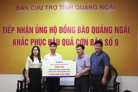 Đại diện Công ty cổ phần ôtô Trường Hải trao tiền hỗ trợ. (Ảnh: Đinh Hương/TTXVN)