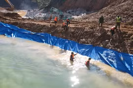 Lực lượng chức năng nắn dòng chảy mới được tạo nên để phục vụ công tác tìm kiếm dưới lòng suối Rào Trăng. (Ảnh: TTXVN phát)