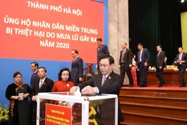 Ông Vương Đình Huệ, Ủy viên Bộ Chính trị, Bí thư Thành ủy, Trưởng đoàn đại biểu Quốc hội thành phố Hà Nội cùng các đại biểu thành phố ủng hộ nhân dân miền Trung bị thiệt hại do mưa lũ gây ra năm 2020. (Ảnh: Văn Điệp/TTXVN)