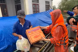 Hỗ trợ lương thực cho người dân vùng lũ. (Ảnh: TTXVN phát)