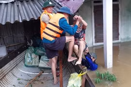 Lực lượng chức năng giúp người dân di dời đến nơi an toàn. (Ảnh: TTXVN phát)