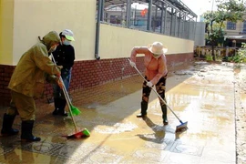 Dọn bùn đất sau lũ. (Ảnh: Võ Dung/TTXVN)