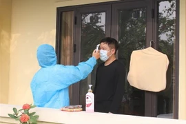 Kiểm tra thân nhiệt thường xuyên cho người cách ly tại Khách sạn Đồng Nê, xã Ninh Thắng, huyện Hoa Lư, tỉnh Ninh Bình. (Ảnh: Thùy Dung/TTXVN)