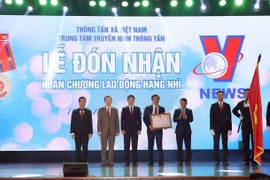 Tổng Giám đốc Thông tấn xã Việt Nam Nguyễn Đức Lợi trao Huân chương Lao động hạng Nhì của Chủ tịch nước tặng Trung tâm Truyền hình Thông tấn. (Ảnh: Phan Tuấn Anh/TTXVN)
