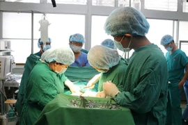 Các bác sỹ Bệnh viện Chợ Rẫy phẫu thuật lấy khối u vòm mũi họng cho bệnh nhân. (Ảnh: TTXVN phát)
