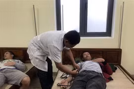 Bác sỹ quân y của Đồn Biên phòng Vinh Hiền chăm sóc sức khỏe cho thuyền viên tàu hàng Công Thành 27. (Ảnh: TTXVN phát)