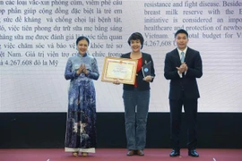 Chủ tịch Liên hiệp các tổ chức hữu nghị Việt Nam Nguyễn Phương Nga (trái) và Phó Chủ tịch kiêm Tổng Thư ký Liên hiệp Hữu nghị-Phó Chủ nhiệm Ủy ban công tác về các tổ chức phi chính phủ nước ngoài Phan Anh Sơn (phải) trao Bằng khen và biểu trưng cho các tổ