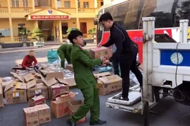 Bàn giao số hàng hóa không có hóa đơn, giấy tờ chứng minh xuất xứ, nguồn gốc cho cơ quan chức năng tiếp tục điều tra, làm rõ. (Ảnh: TTXVN phát)