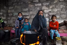 Người dân Palestine sưởi ấm tại trại tị nạn ở thành phố Khan Younis, Dải Gaza ngày 26/11/2020. (Ảnh: THX/TTXVN)