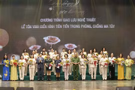 Phó Thủ tướng Vũ Đức Đam và Thượng tướng Lê Quý Vương, Thứ trưởng Bộ Công an trao tặng biểu trưng và hoa chúc mừng, tôn vinh điển hình tiên tiến trong phòng, chống ma túy. (Ảnh: Doãn Tấn/TTXVN)