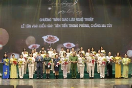 Phó Thủ tướng Vũ Đức Đam và Thượng tướng Lê Quý Vương, Thứ trưởng Bộ Công an trao tặng biểu trưng và hoa chúc mừng, tôn vinh điển hình tiên tiến trong phòng, chống ma túy. (Ảnh: Doãn Tấn/TTXVN)