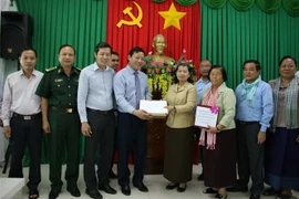 Phó Chủ tịch UBND tỉnh Long An Phạm Tấn Hòa tiếp nhận số tiền 500 triệu đồng do bà Men Som On - Phó Thủ tướng Chính phủ Hoàng gia Campuchia trao tặng người dân miền Trung bị ảnh hưởng bởi bão lũ. (Ảnh: Bùi Giang/TTXVN)
