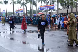Các vận động viên chạy vũ trang tranh tài ở nội dung hệ đội tuyển các quận, huyện. (Ảnh: Trần Lê Lâm/TTXVN)