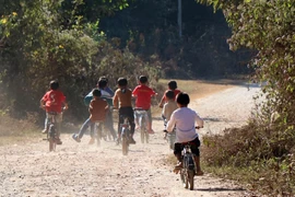 Học sinh dân tộc Khơ mú trên đường đi học về. (Ảnh: Xuân Tiến/TTXVN)