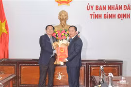Thừa ủy quyền của Thủ tướng Chính phủ, ông Hồ Quốc Dũng - Bí thư Tỉnh ủy, Chủ tịch HĐND tỉnh Bình Định (trái) trao quyết định của Thủ tướng Chính phủ cho ông Nguyễn Phi Long, Chủ tịch UBND tỉnh Bình Định. (Ảnh: Phạm Kha/TTXVN)
