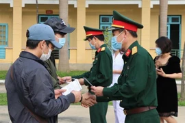 Lãnh đạo Bộ Chỉ huy quân sự tỉnh Hòa Bình trao giấy chứng nhận hoàn thành thời gian cách ly cho công dân. (Ảnh: Thanh Hải/TTXVN)