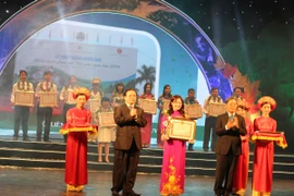 Phó Thủ tướng Hoàng Trung Hải và Bộ trưởng Tài nguyên-Môi trường Nguyễn Minh Quang trao kỷ niệm chương cho các tập thể điển hình tiên tiến. (Ảnh: Hùng Võ/Vietnam+)