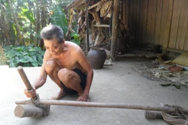 Ông Mông Văn Sau đang trau chuốt đồ nghề hoạn trâu, bò. (Ảnh: PV/Vietnam+)