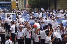 Hàng trăm tài xế taxi Vinasun cầm theo băng rôn, biểu ngữ đến dự phiên tòa. (Ảnh: Thành Chung/TTXVN)