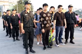 Công an tỉnh Lào Cai bàn giao các đối tượng cho Công an Trung Quốc tại Cửa khẩu Quốc tế Lào Cai. (Ảnh: Hồng Ninh/TTXVN)