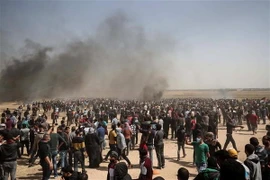 Người biểu tình Palestine trong cuộc xung đột với lực lượng an ninh Israel ở khu vực biên giới Gaza-Israel. (Nguồn:AFP/TTXVN)