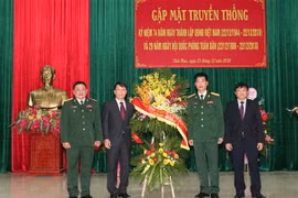 Tổng giám đốc TTXVN Nguyễn Đức Lợi tặng hoa chúc mừng Sư đoàn 304. (Ảnh: Văn Điệp/TTXVN)