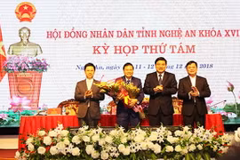 Lãnh đạo tỉnh tặng hoa chúc mừng ông Lê Hồng Vinh. (Nguồn: nghean.gov.vn)