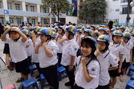 Các em học sinh trường Tiểu học Ba Đình, Hà Nội, đội mũ bảo hiểm. (Ảnh: Trần Việt/TTXVN)