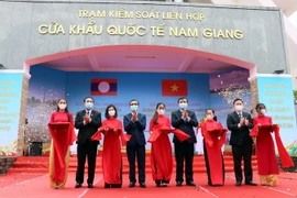 Lãnh đạo hai tỉnh Quảng Nam và Sekong (Lào) cắt băng khai trương cặp cửa khẩu quốc tế Nam Giang-Dak Taook. (Ảnh: Trần Tĩnh/TTXVN)