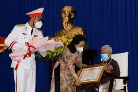 Bà Nguyễn Thị Lệ, Chủ tịch Hội đồng Nhân dân Thành phố Hồ Chí Minh thừa ủy quyền Chủ tịch nước trao tặng danh hiệu Bà mẹ Việt Nam Anh hùng cho mẹ Nguyễn Thị Sua. (Ảnh: Thanh Vũ/TTXVN)