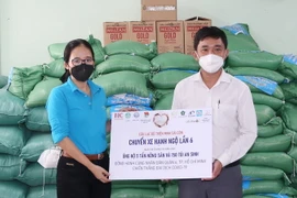 Bà Bùi Thị Cẩm Huyền, Phó Chủ nhiệm Câu lạc bộ Thiện Minh Sài Gòn trao 5 tấn nông sản và 150 túi an sinh tặng các gia đình có hoàn cảnh khó khăn do đại dịch. (Ảnh: TTXVN phát)
