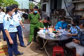 Lực lượng chức năng tiến hành lập biên bản, tạm giữ lô hàng cấm. (Ảnh: Hồng Điệp/TTXVN)