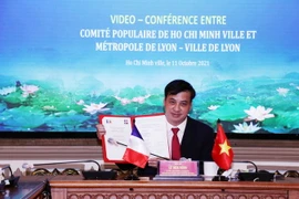 Ông Lê Hòa Bình, Phó Chủ tịch UBND Thành phố ký Biên bản ghi nhớ thỏa thuận hợp tác giữa hai thành phố trong dự án chiếu sáng đô thị tòa nhà Kho bạc Nhà nước Thành phố Hồ Chí Minh. (Ảnh: Xuân Khu/TTXVN)