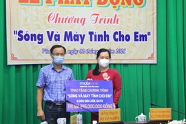 Các đơn vị trao bảng tượng trưng hỗ trợ Chương trình “Sóng và máy tính cho em” tại tỉnh Vĩnh Long. (Ảnh: Lê Thúy Hằng/TTXVN)