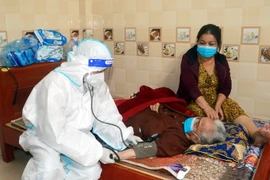 Cán bộ y tế kiểm tra sức khỏe cho người già yếu, mắc bệnh nặng. (Ảnh: Nguyễn Lành/TTXVN)