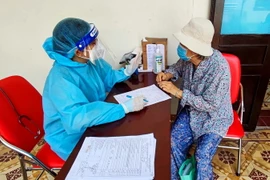 Tiêm vaccine phòng COVID-19 cho người già có hoàn cảnh neo đơn đang sinh sống tại Trung tâm Dưỡng lão Thị Nghè, TP.HCM. (Ảnh: TTXVN phát)