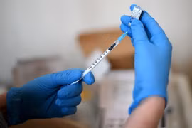 Nhân viên y tế chuẩn bị tiêm vaccine phòng COVID-19 cho người dân. (Ảnh: AFP/TTXVN)