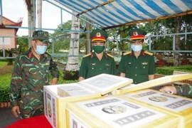 Bộ Chỉ huy quân sự tỉnh Bạc Liêu tổ chức tiếp nhận và kiểm tra tro cốt nhân dân tử vong do COVID-19 trước khi bàn giao cho gia đình. (Ảnh: Nhật Bình/TTXVN)